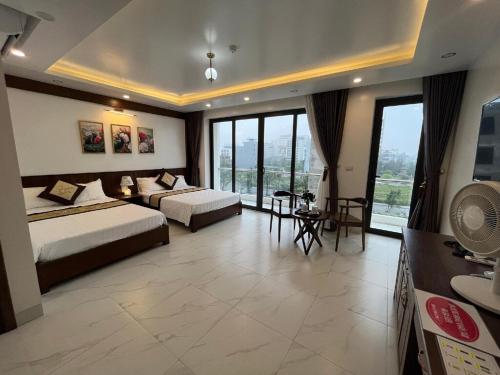a hotel room with two beds and a large window at Khách Sạn Moonlight FLC Sầm Sơn in Sầm Sơn