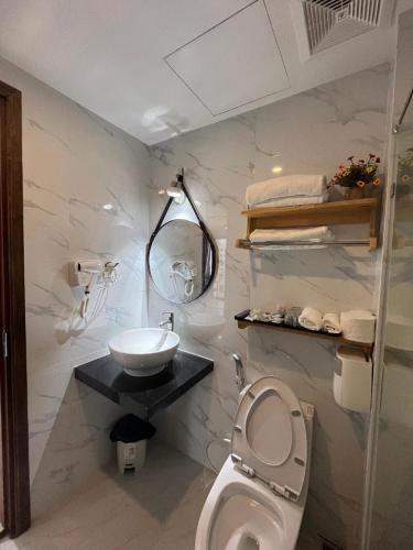 a bathroom with a sink and a toilet at Khách Sạn Moonlight FLC Sầm Sơn in Sầm Sơn