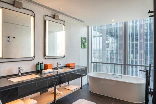 a bathroom with two sinks and a bath tub at Novotel Xi'an Aden in Xi'an