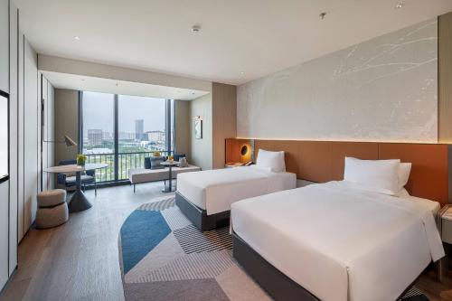 two beds in a hotel room with a view at Novotel Xi'an Aden in Xi'an