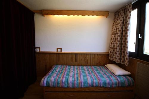 a small bed in a room with a window at Résidence Palafour - Studio pour 2 Personnes 371 in Tignes