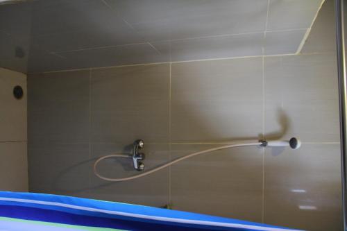 a shower with a shower head in a bathroom at Puri Bunga Beach Cottages in Senggigi 