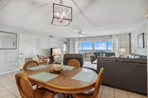 a living room with a table and a couch at Oceanfront Condo w Balcony in Amelia Island