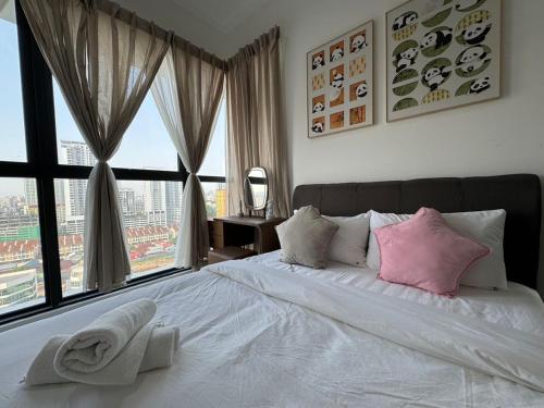 a bedroom with a large white bed with pink pillows at DeLuma-Urban Suites in Jelutong