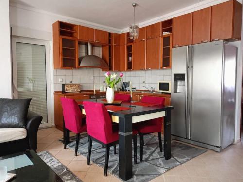 a kitchen with a table with red chairs and a refrigerator at Layla Home in Alexandroupoli