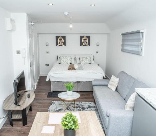 uma sala de estar com uma cama e um sofá em Aylesbury Studio-6 with parking em Buckinghamshire
