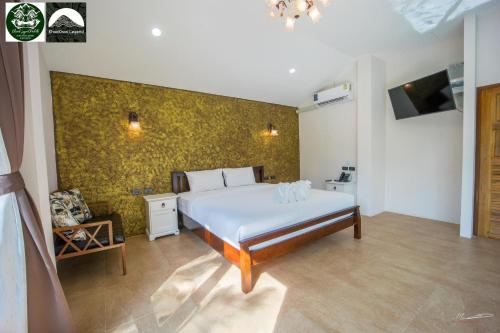 a bedroom with a bed and a yellow wall at Khaosok Legend phase 2 in Khao Sok National Park