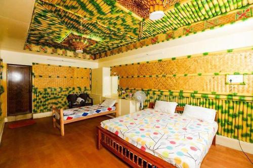1 Schlafzimmer mit 2 Betten und einer Wand mit Wandbild in der Unterkunft Sejour D Confort (Bamboo Stays) in Puducherry