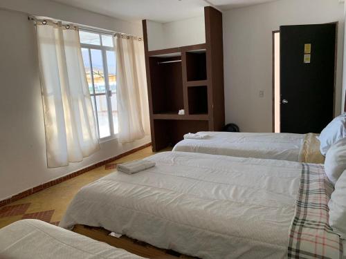 sypialnia z 2 łóżkami i oknem w obiekcie HOTEL PUERTO REAL SUITES w mieście Paraíso