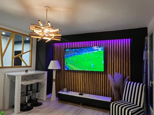 un salon avec une télévision sur un mur dans l'établissement Logement lumineux pour 6 personnes, à La Roche-sur-Yon