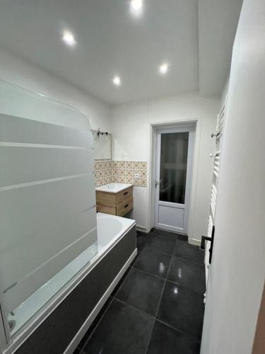 une salle de bain avec une baignoire et un lavabo dans l'établissement Logement lumineux pour 6 personnes, à La Roche-sur-Yon