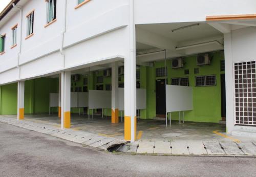 an empty building with green walls and white columns at JQ Suria Hotel in Lahat