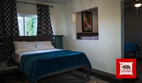 HOTEL CALICOMFORT في تيكاته: غرفة نوم عليها سرير وبطانية زرقاء