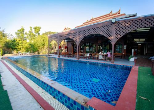 a swimming pool at a resort with a building at พรพนาฮิลล์รีสอร์ท in Ban Makok