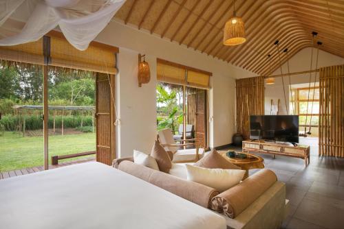 a bedroom with a bed and a living room at Alba Wellness Resort By Fusion in Hue