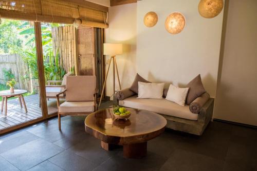 a living room with a couch and a coffee table at Alba Wellness Resort By Fusion in Hue