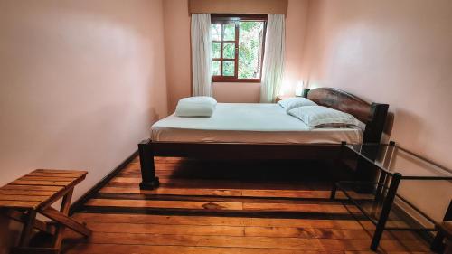 a bed in a room with a window at Quarto Aconchegante na - Peniel Guesthouse in Gramado