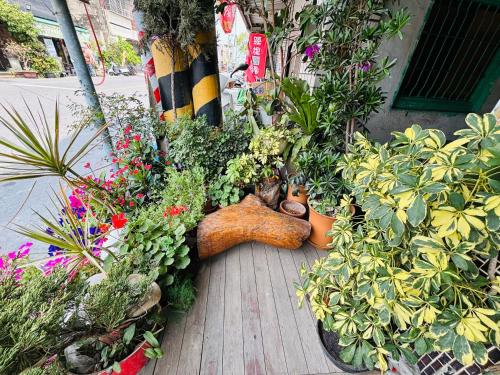 un jardin avec des plantes et un animal farci posé sur une terrasse couverte dans l'établissement Xingang Homestay, à Xingang