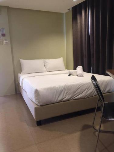 - un lit avec des draps et des oreillers blancs dans l'établissement Spacious Studio Apartment B203, à Manille
