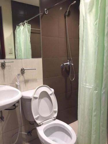 La salle de bains est pourvue de toilettes, d'un lavabo et d'une douche. dans l'établissement Spacious Studio Apartment B203, à Manille