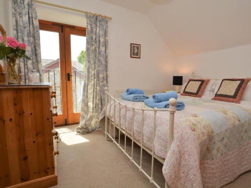 a bedroom with a bed with blue pillows at 4 bed in Sherborne FOLOW in Long Burton