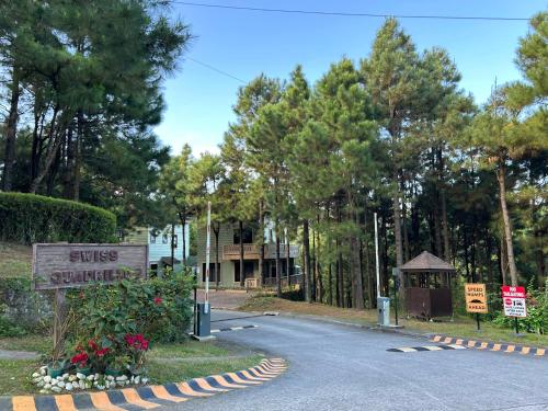 a road with a sign and a house with trees at Crosswinds Nature View Suite in Tagaytay