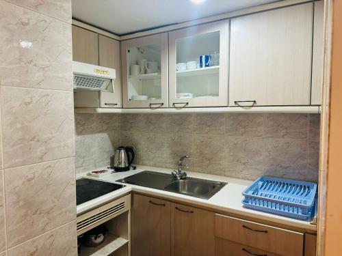 een kleine keuken met een spoelbak en een aanrecht bij Fully Furnished Omni Tower Apartments Nana - Sukhumvit soi 4 in Bangkok