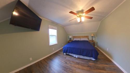 a bedroom with a bed and a ceiling fan at River Dream Lake Murray Getaway in Saluda
