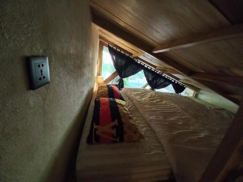 een slaapkamer met 2 stapelbedden en een lichtschakelaar bij Reureuh Cabin in Batukaras