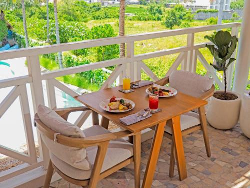 a table with two plates of food on a balcony at IZE Canggu by LifestyleRetreats in Canggu