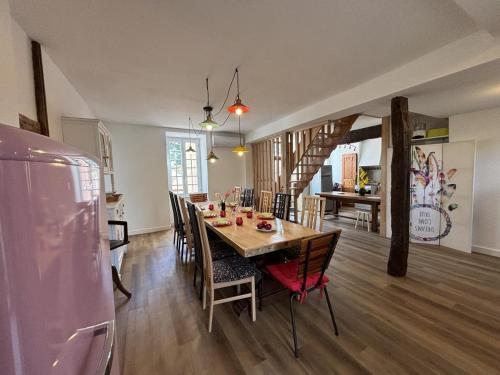 une cuisine et une salle à manger avec une table et des chaises dans l'établissement Grande maison rénovée avec jardin clos, idéale pour familles et amis, équipements variés, animaux acceptés - FR-1-489-50, à Trézelles