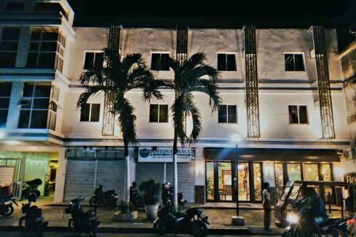 dos palmeras delante de un edificio por la noche en Belladama Hotel, en San Carlos