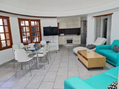 een woonkamer met een blauwe bank en een tafel bij Ferienhaus für 8 Personen ca 160 qm in Puerto del Carmen, Lanzarote Südküste von Lanzarote in Puerto del Carmen