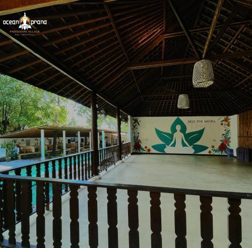 a yoga studio with aitating room with a wall with a mural at Ocean Prana Village in Amed