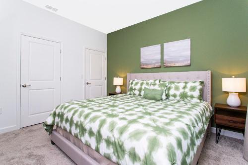 a bedroom with a large bed with a green wall at 1056 LS - Luxury 4BR3BA - Champions Gate Bliss in Kissimmee