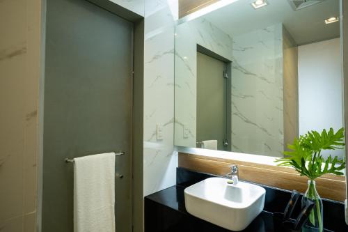 a bathroom with a sink and a mirror at Amber Hotel - Cebu in Cebu City