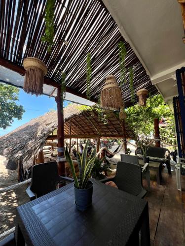 a patio with a table and chairs and an umbrella at Hostel Beach House in Rincón