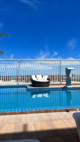 a swimming pool with a couch in the middle of it at Pousada Diana Maragogi in Maragogi