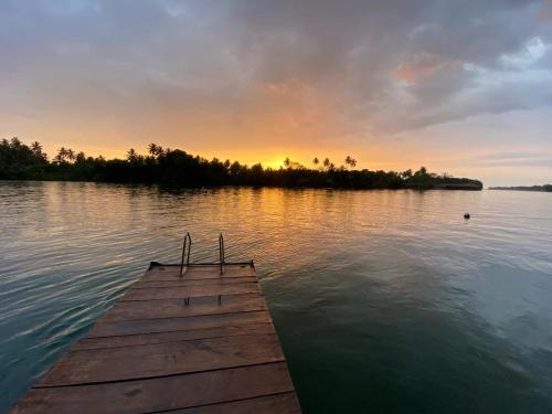 a dock on a body of water at sunset at Residence Jasmine in Aluthgama