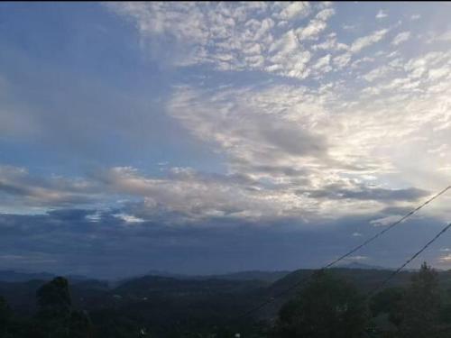 a cloudy sky with a view of a mountain at The Jungle Life Homestay Thangamalay Sanctuary Haputale by Gisela Sivam in Haputale