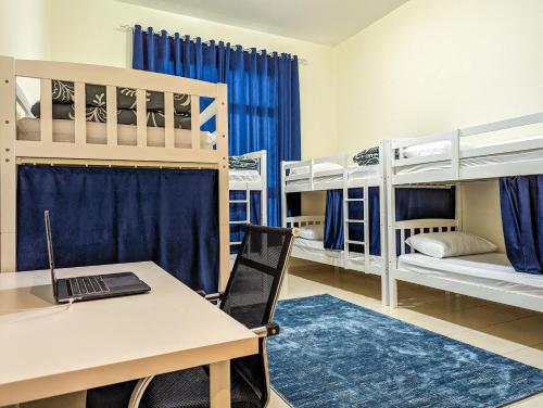 a room with a desk and a laptop on a table at Comfort Bed Inn in Dubai