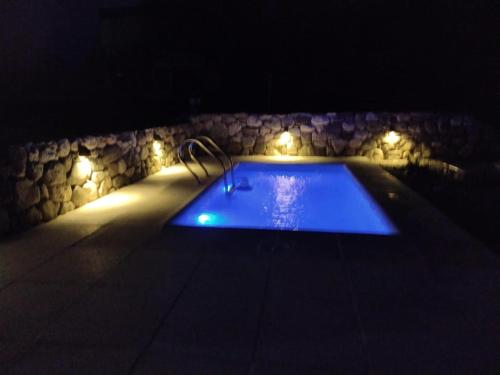 uma piscina à noite com luzes em Casa la bien amada em Merlo