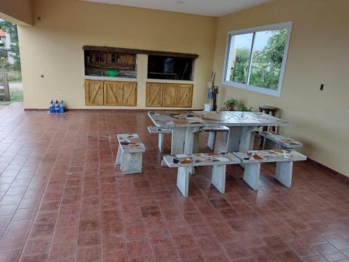 uma sala com mesas e bancos num piso de azulejo em Casa la bien amada em Merlo