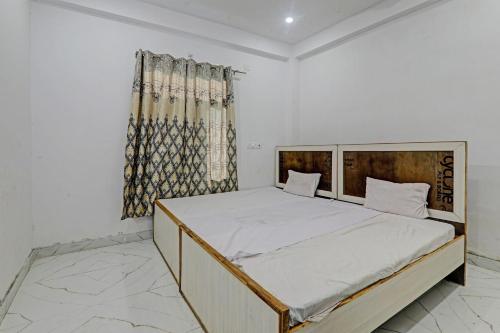 1 dormitorio con 1 cama grande con sábanas blancas y ventana en OYO ONCE MORE RESTAURANT AND CAFE, en Lukerganj