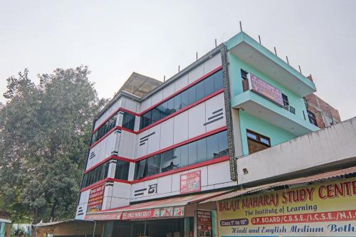 a tall white building with a sign in front of it at OYO ONCE MORE RESTAURANT AND CAFE in Lukerganj