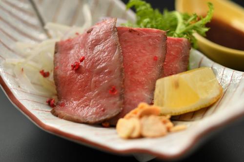 a plate with two pieces of meat and cheese at Kami no yama Azumaya in Kaminoyama
