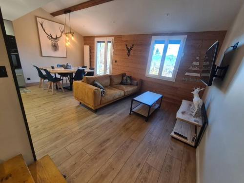 a living room with a couch and a table at Chalet Le Parc de Latour, au pied de la montagne in Latour-de-Carol