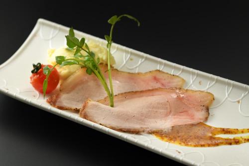 a piece of meat on a plate with a strawberry at Kami no yama Azumaya in Kaminoyama
