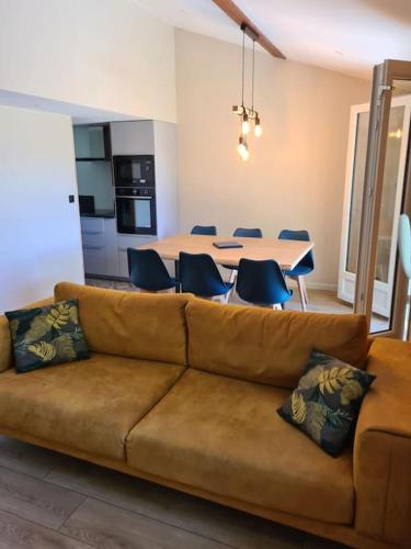 un salon avec un canapé et une table avec des chaises dans l'établissement Chalet Le Parc de Latour, au pied de la montagne, à Latour-de-Carol