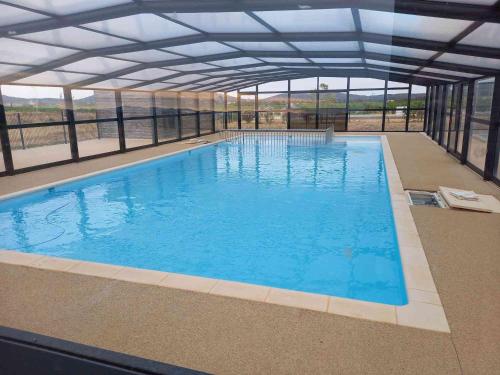 une grande piscine avec un grand plafond dans l'établissement Chalet 3 chambres, piscine, lac à 100m - Olonzac - FR-1-783-1, à Olonzac